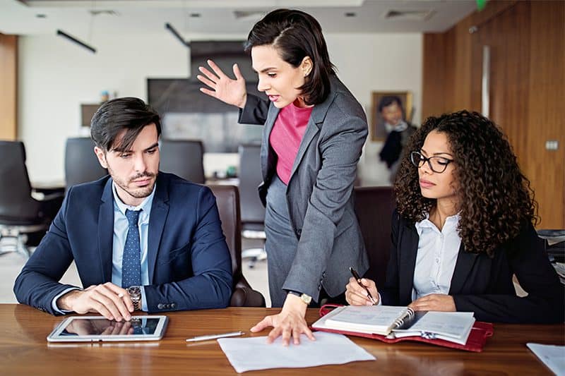 toxic boss in business meeting with her assistants
