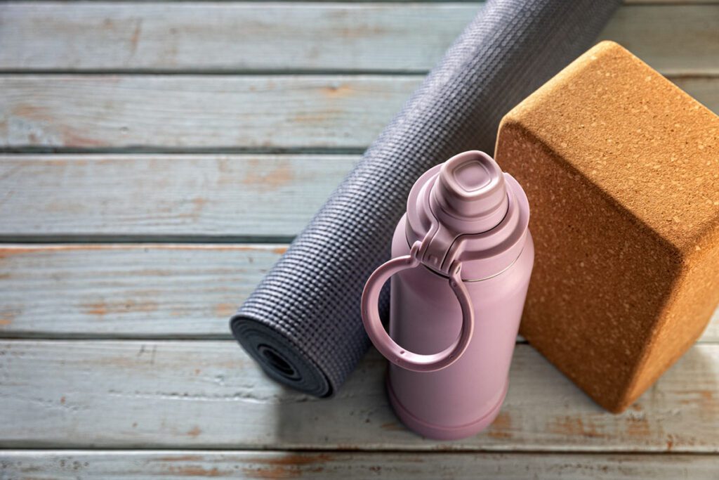 water bottle, yoga mat, and foam block for yogalates