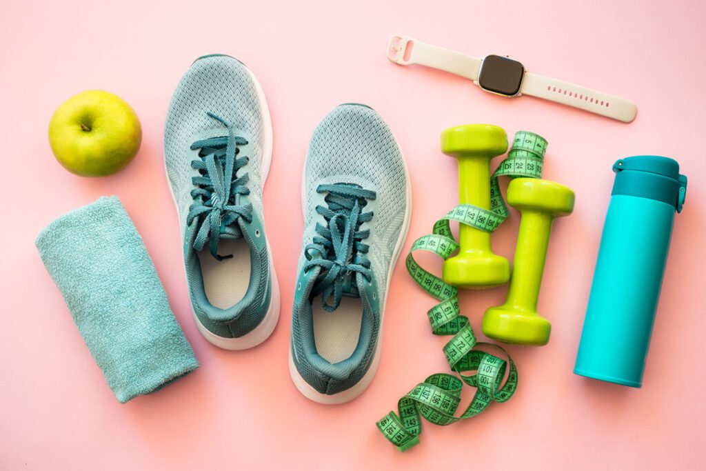 tennis showes, dumbells, and an apple watch on the ground