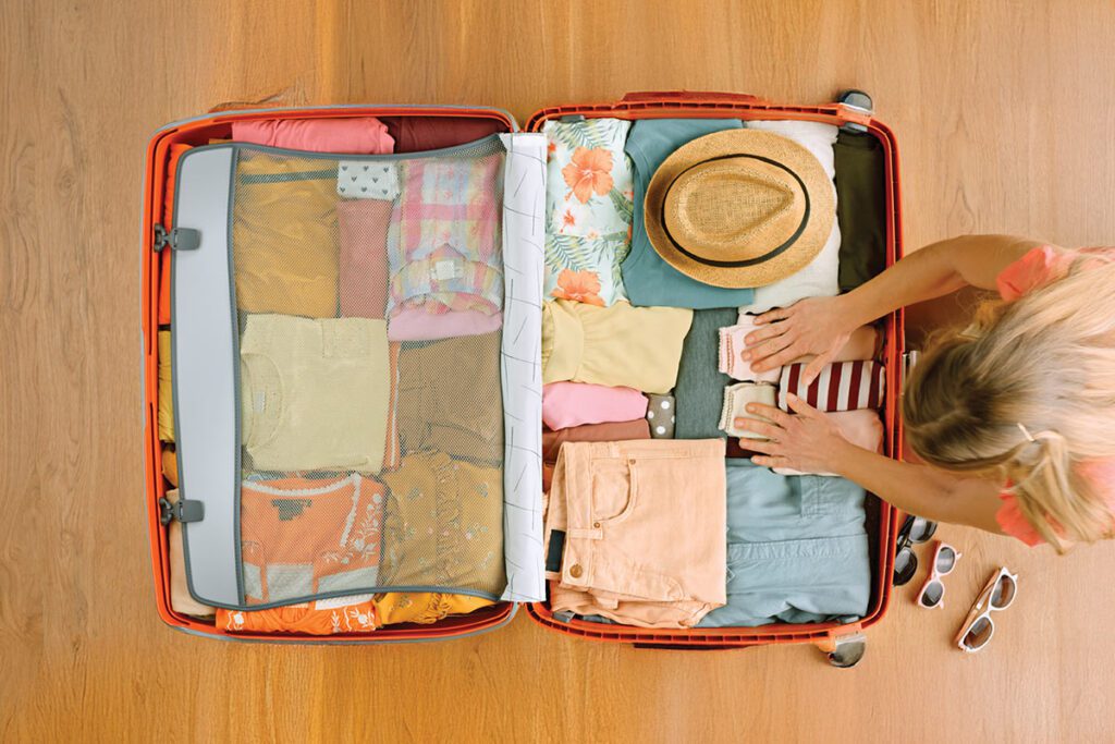 woman packing clothes into a suitcase