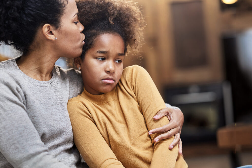 sad girl being hugged by her mom