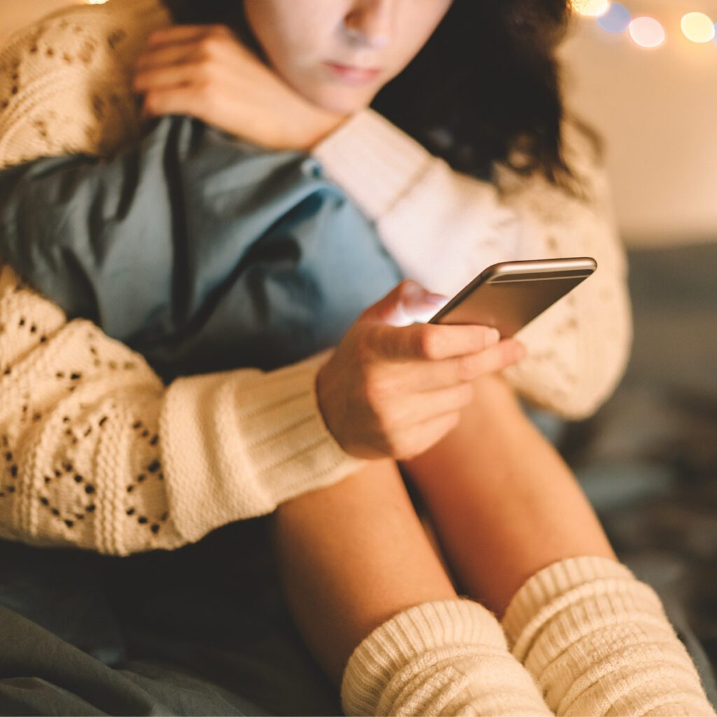 teen on her phone with a gloomy face