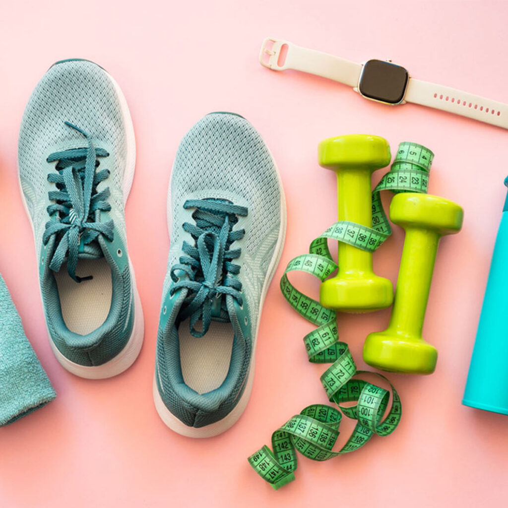 tennis showes, dumbells, and an apple watch on the ground