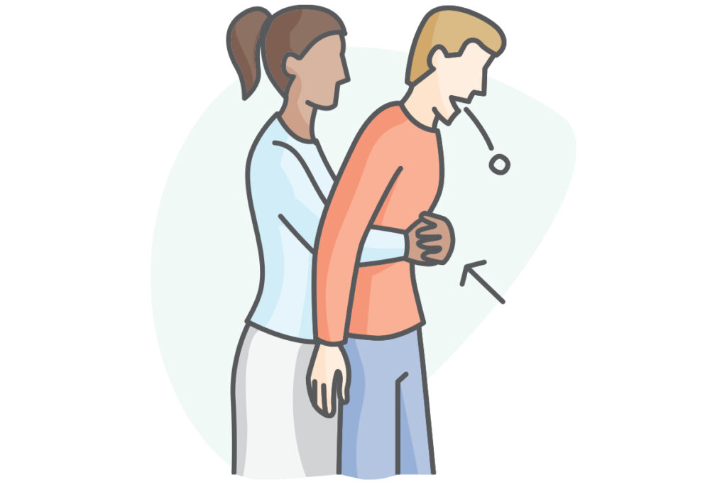 A woman performs the Heimlich maneuver on a man to assist him with a choking emergency.