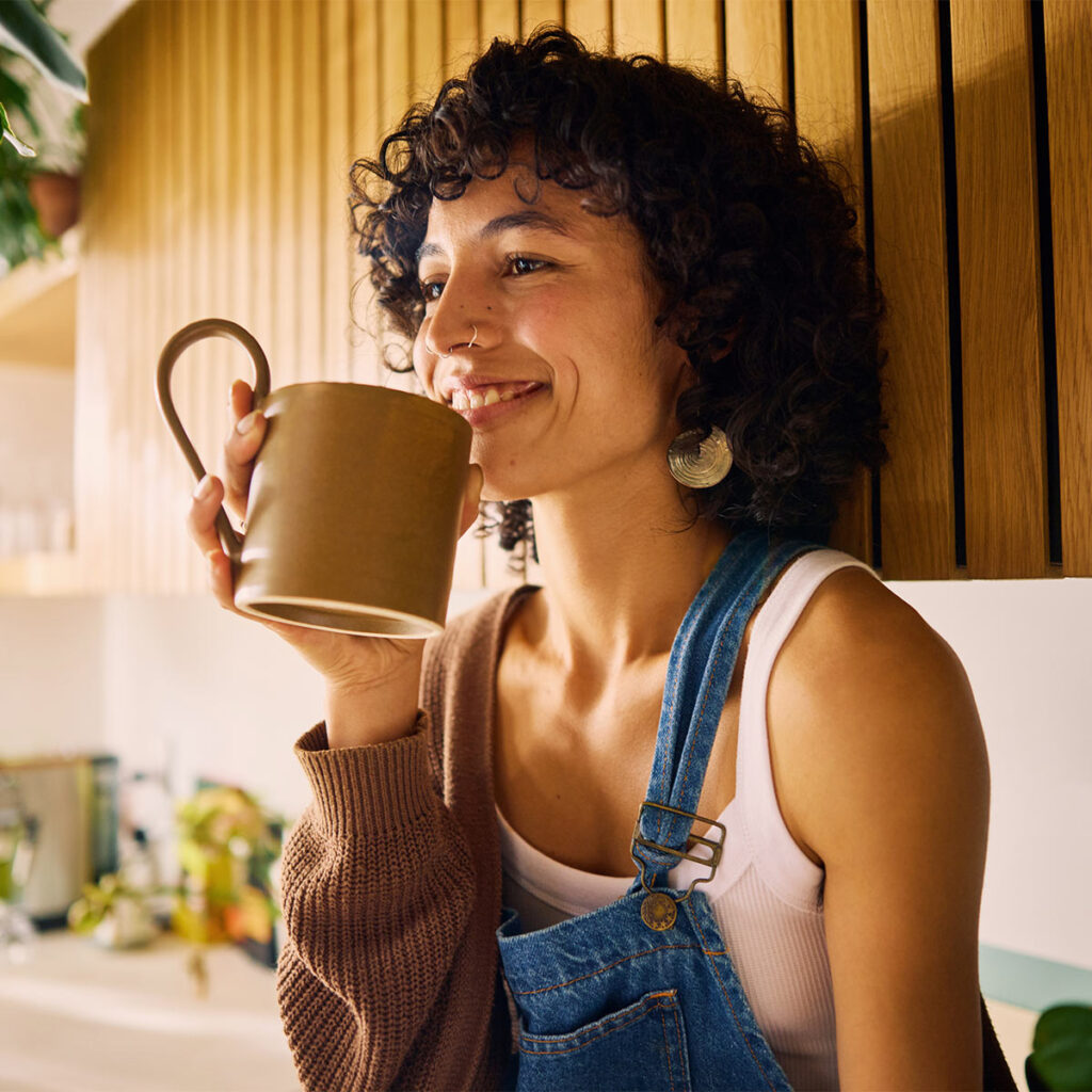 Smiling woman drinking a cup of coffee