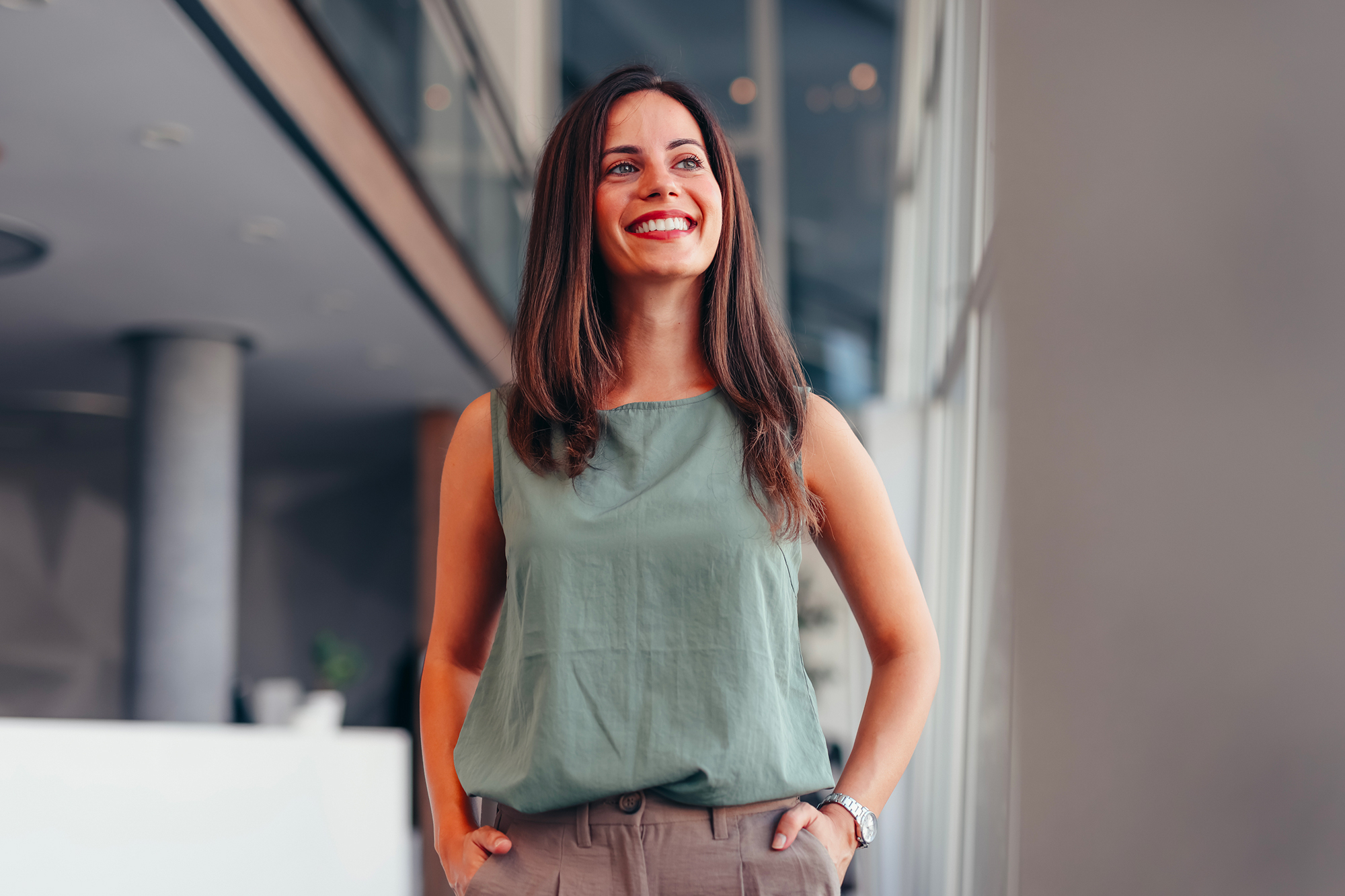 Woman looking away, smiling in teal shirt