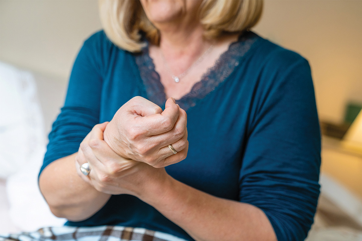 older woman holding her hand