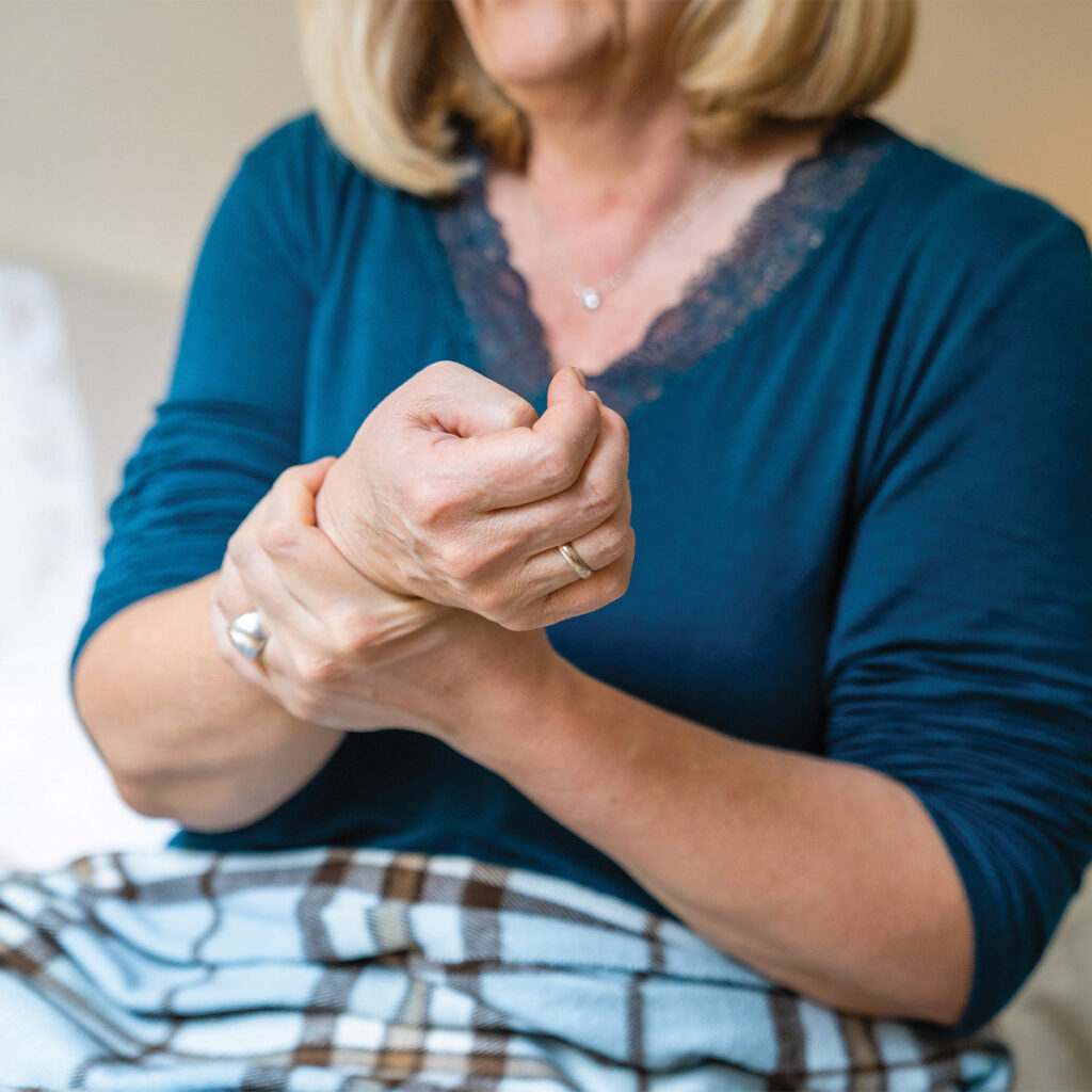 older woman holding her hand