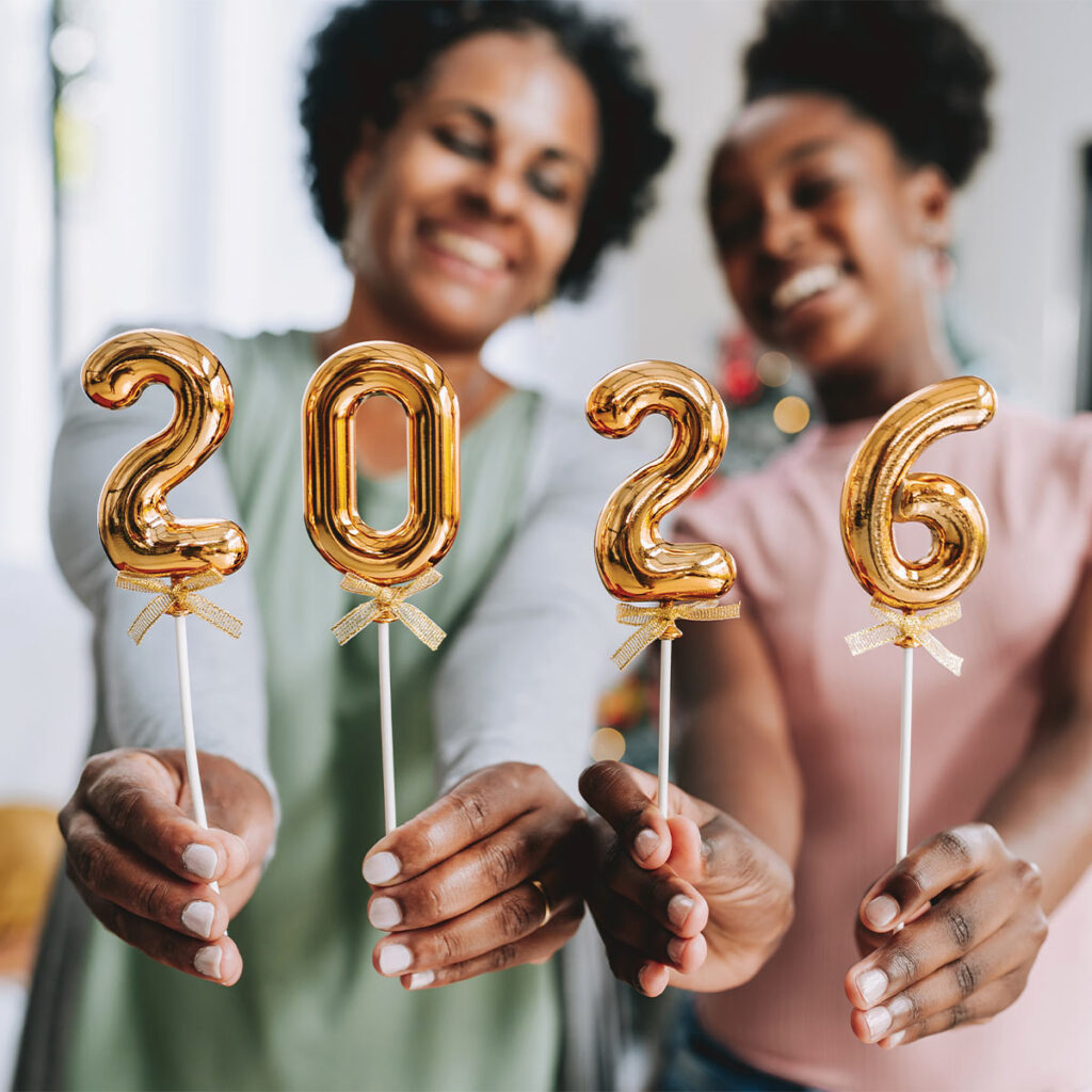 mother and daughter holding up balloons that say 2026