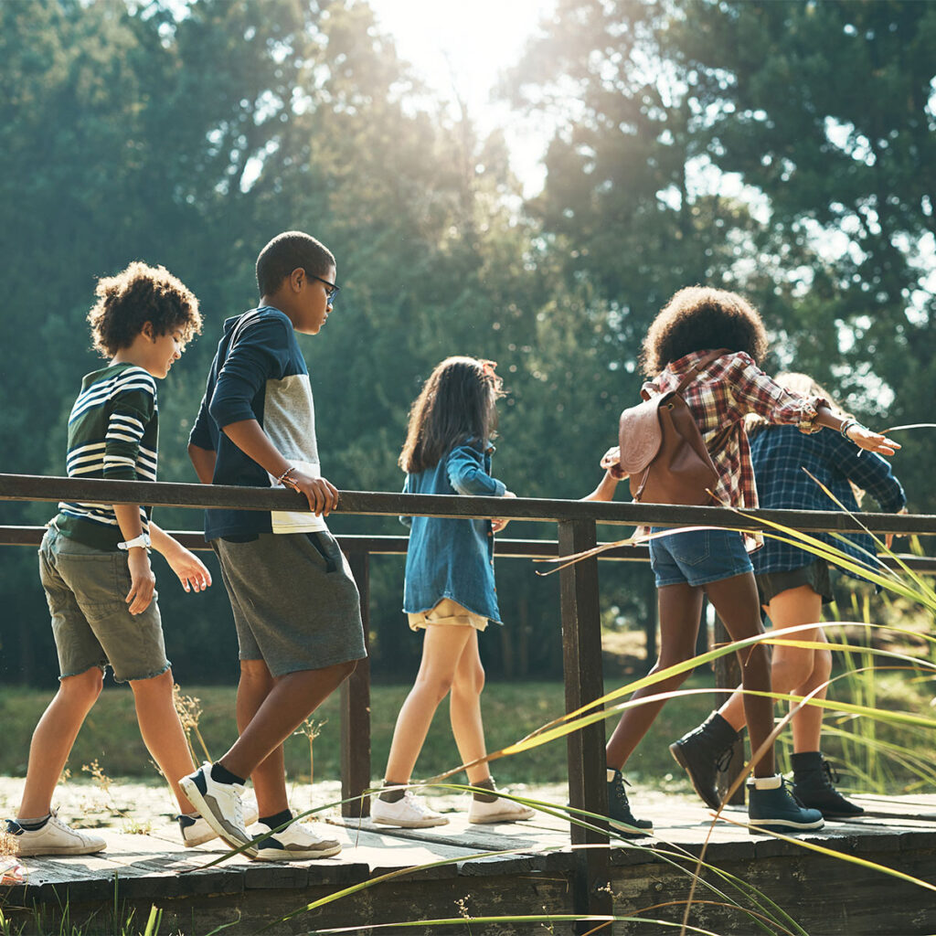 children walking across a bridge at summer camp