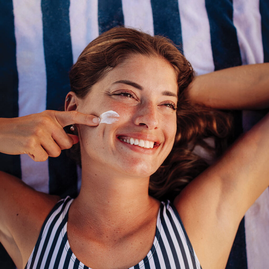 Woman applying sunscreen to face