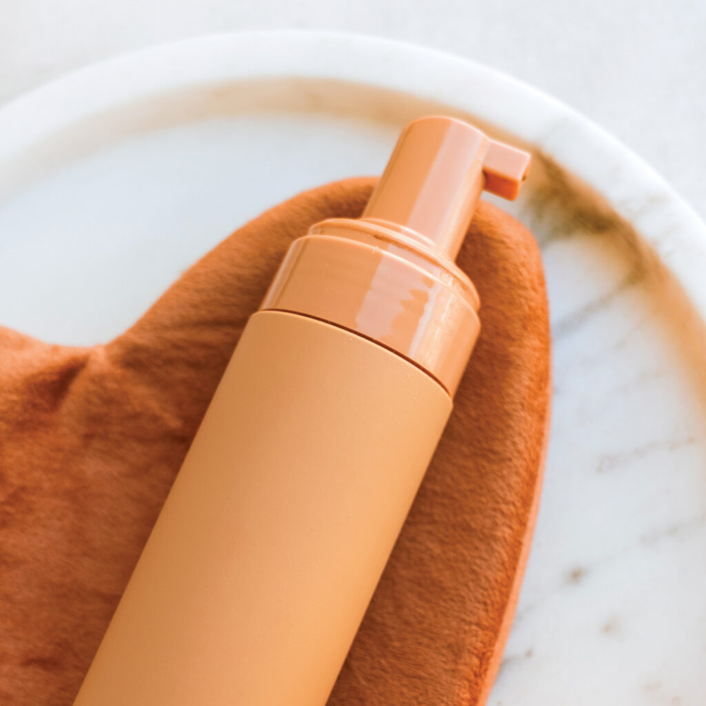 orange self tanner bottle and mitt