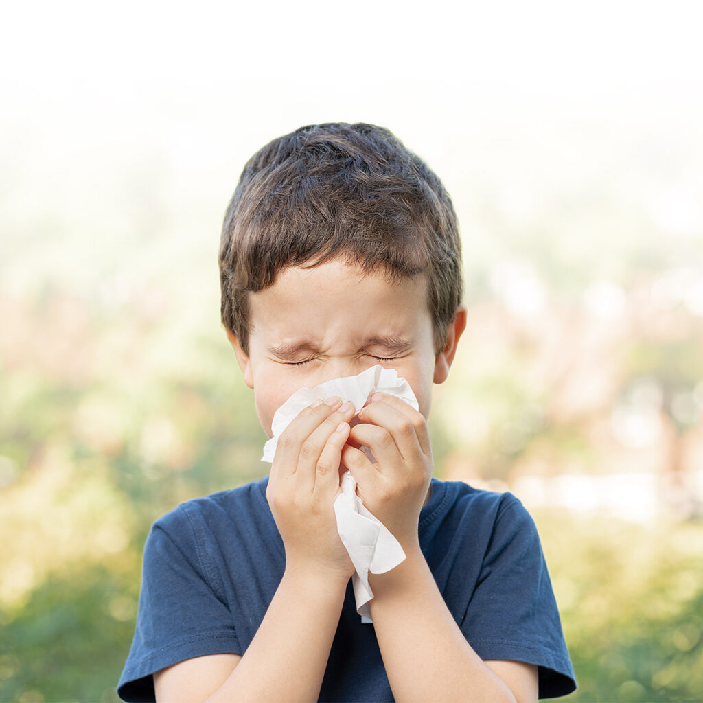 Child sneezing outdoors