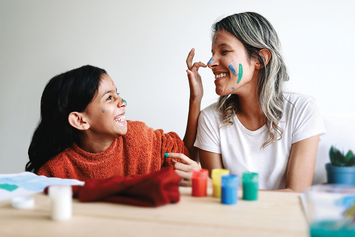 a mother and her daughter playing with paint