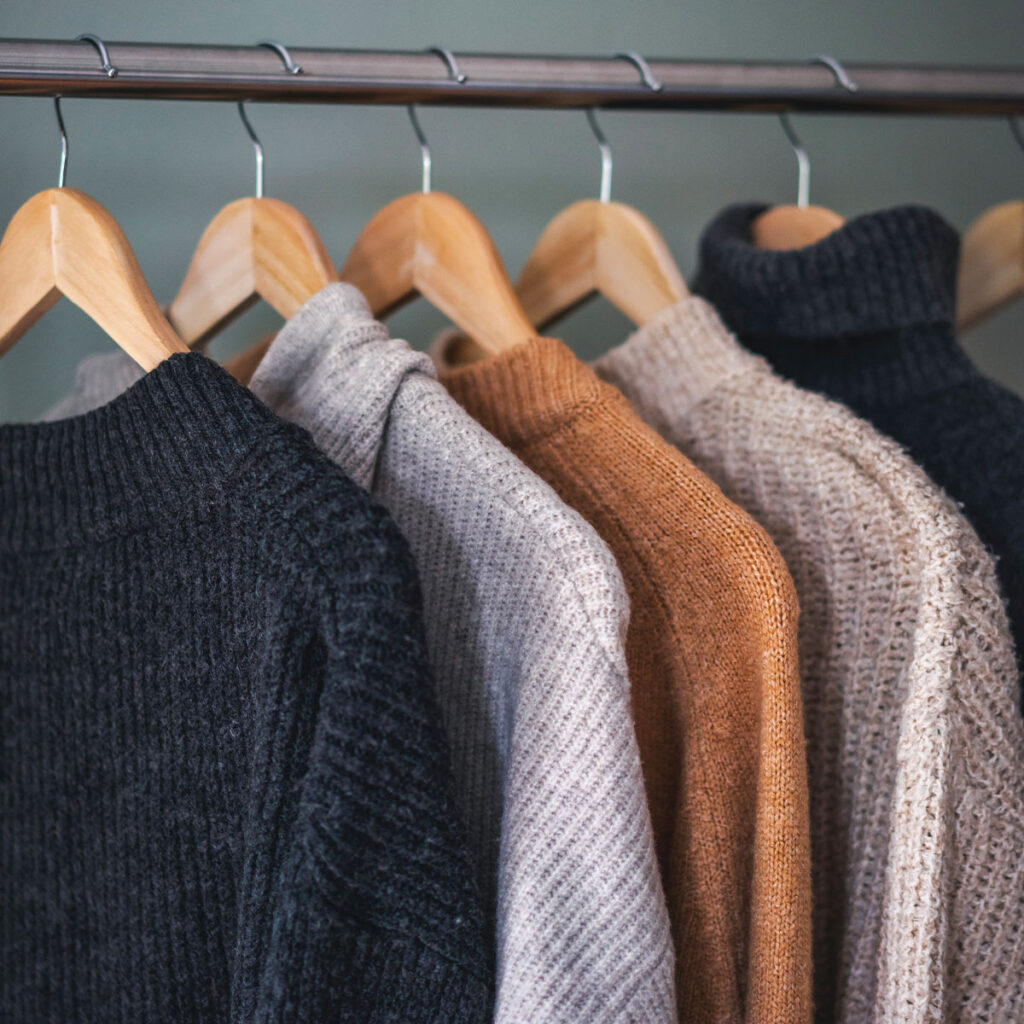 sweaters hanging on rack