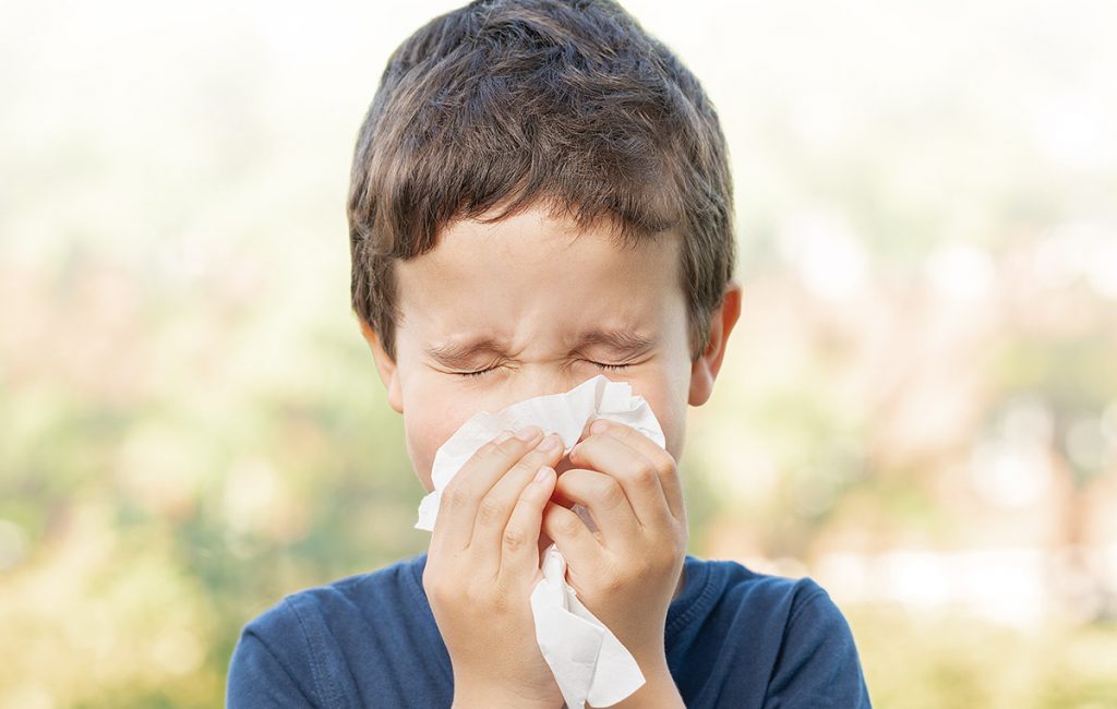 Child sneezing outdoors